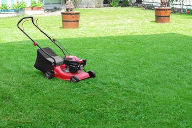 Photo of Modern garden lawn mower on green grass in park