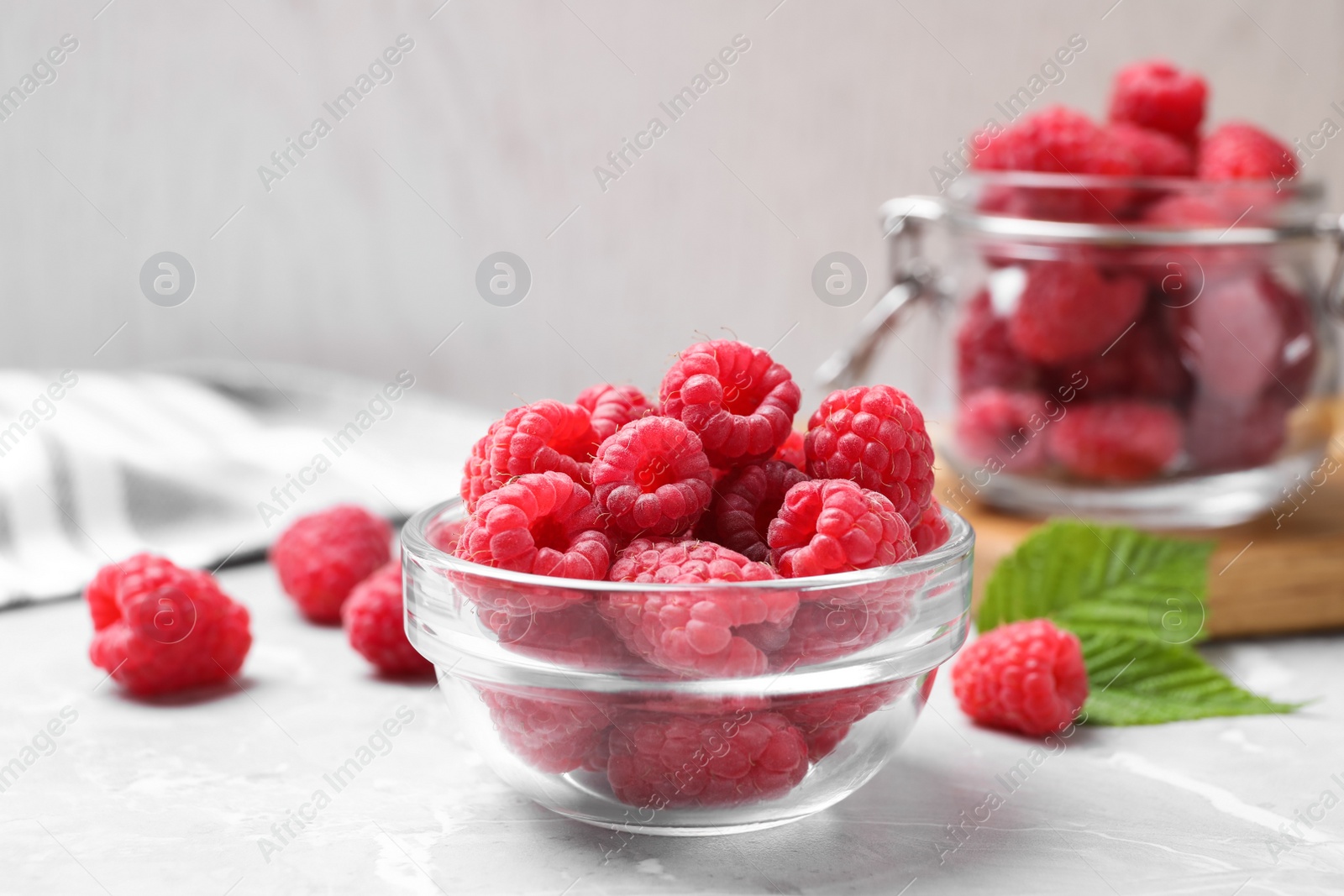 Photo of Delicious fresh ripe raspberries on light grey table