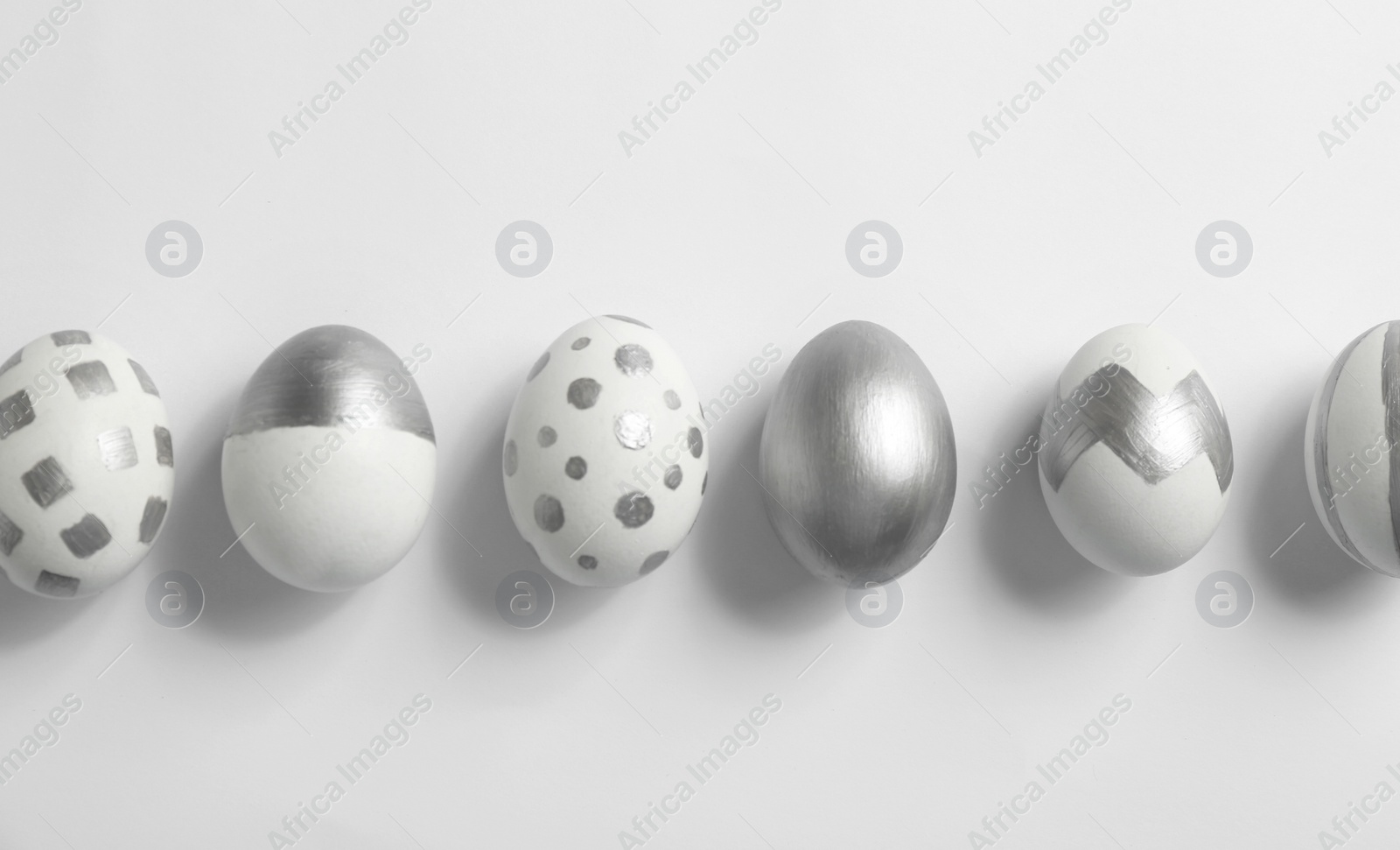 Photo of Painted Easter eggs on white background, top view