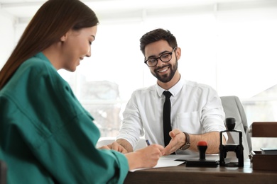 Male notary working with client in office