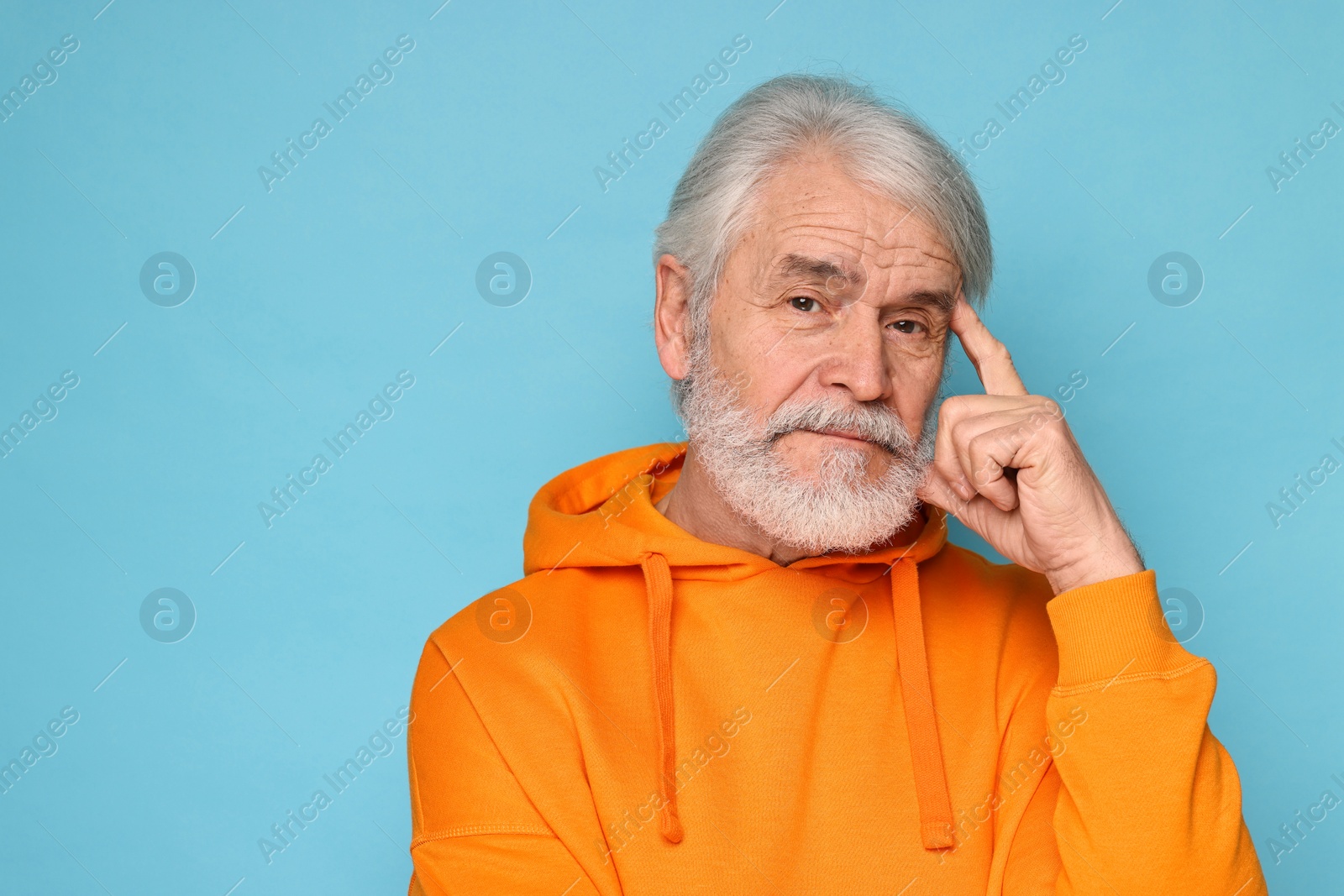 Photo of Senior man with mustache on light blue background, space for text