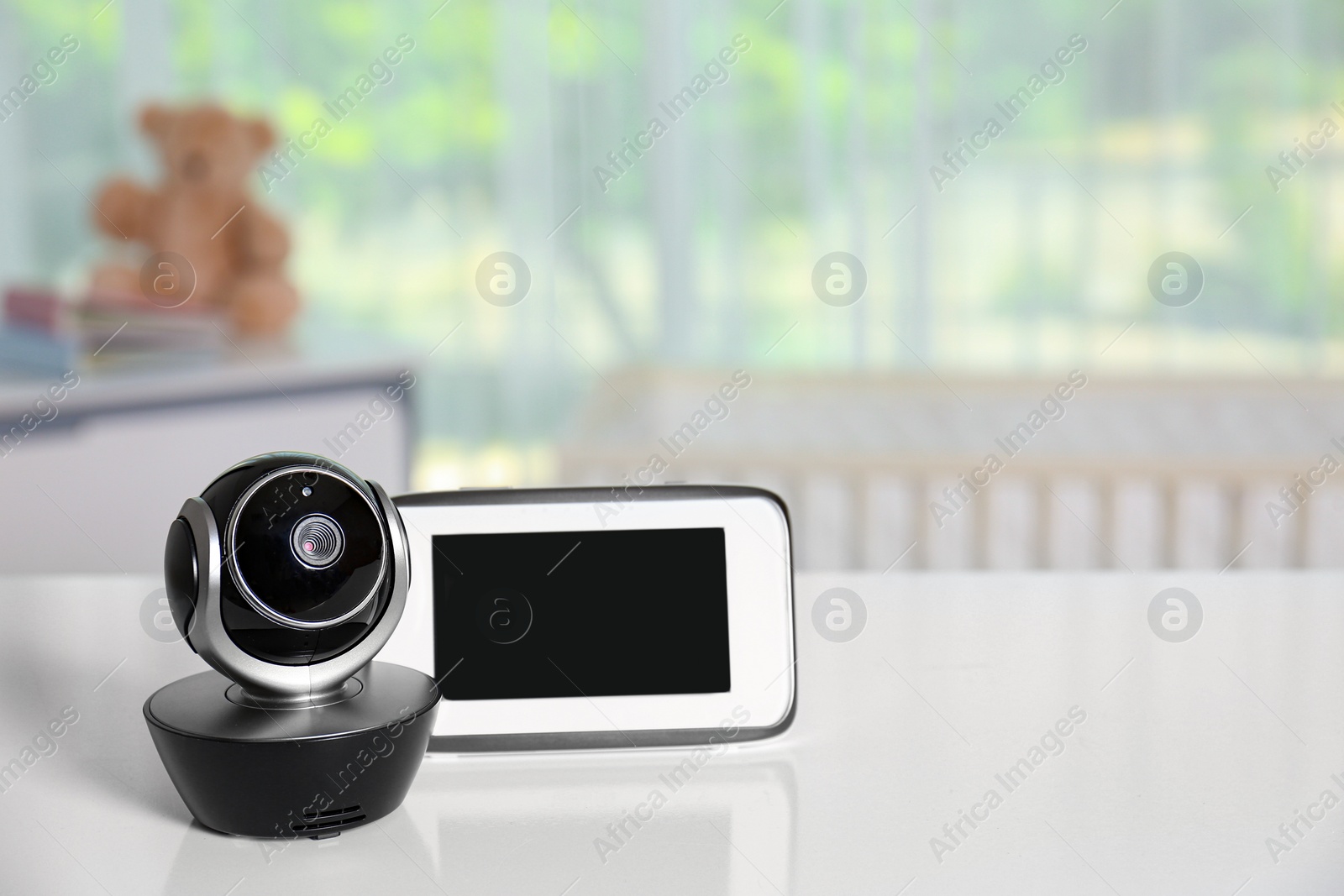 Photo of Baby monitor with camera on table in room, space for text. Video nanny