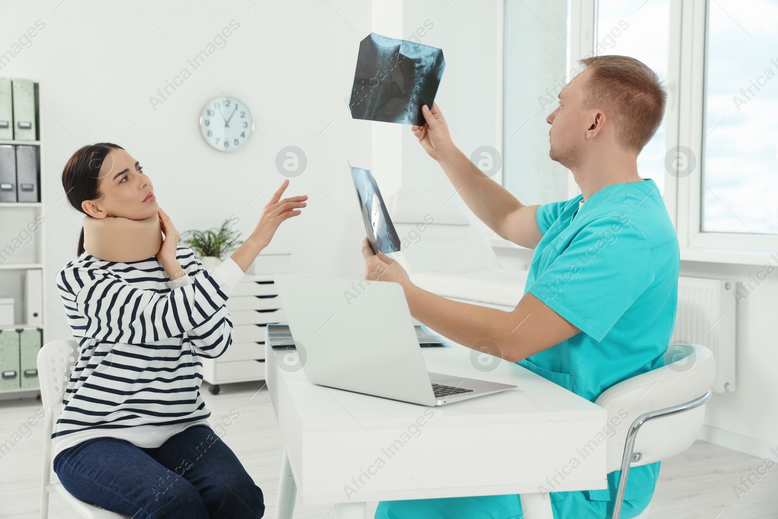 Photo of Doctor with neck MRI images consulting patient in clinic