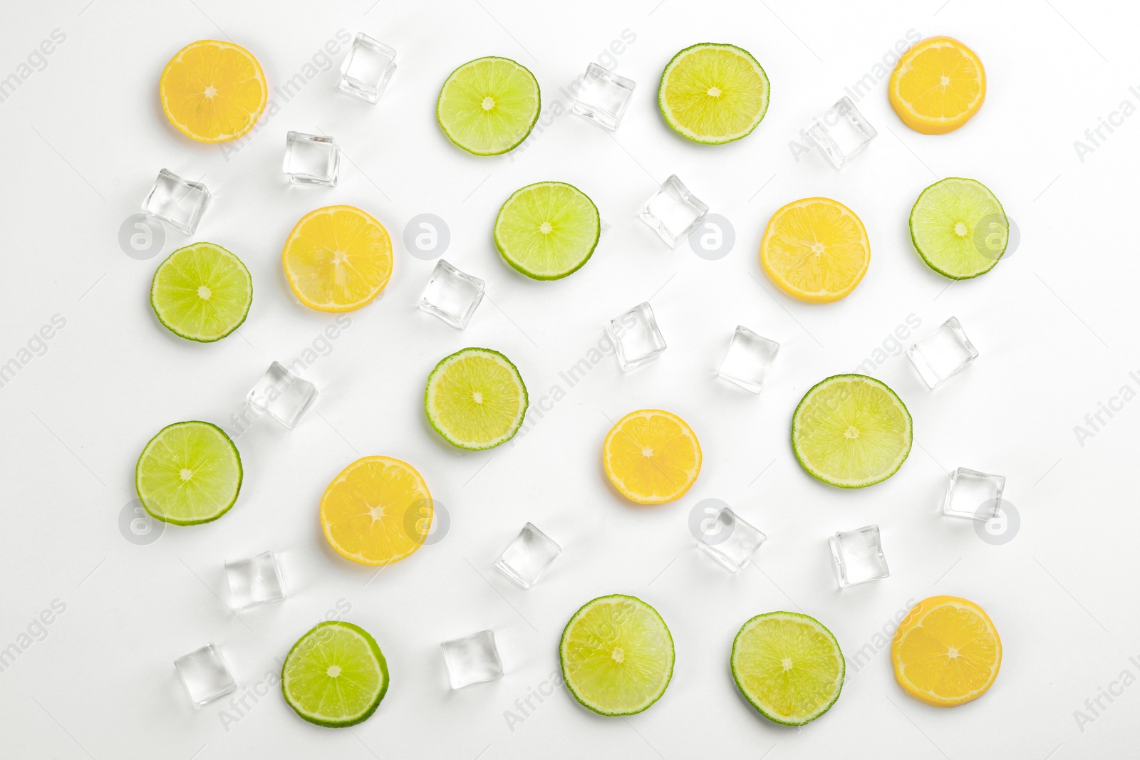 Photo of Lemonade layout with ice cubes, lime and orange slices on white background, top view