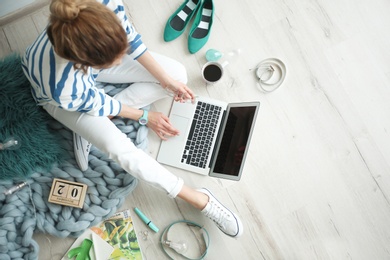 Photo of Female blogger with laptop indoors, top view