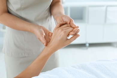 Photo of Woman receiving hand massage in wellness center, closeup