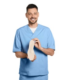 Handsome male orthopedist showing insole on white background