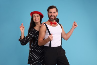 Photo of Happy couple dancing together on light blue background