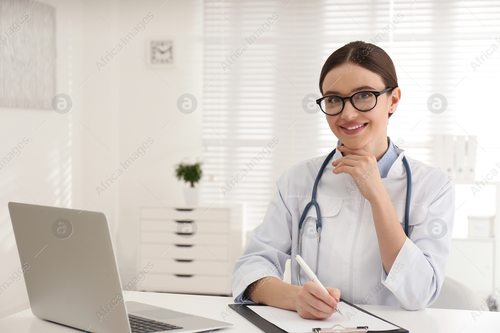 Photo of Portrait of young female doctor in white coat at workplace