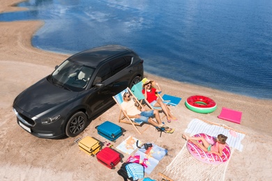 Image of Family with beach accessories and car near river. Summer trip