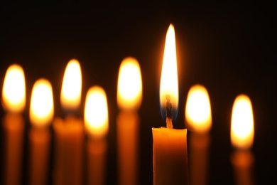 Photo of Burning candles on dark background, space for text. Symbol of sorrow