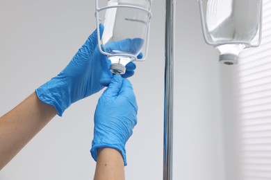 Nurse setting up IV drip in hospital, closeup