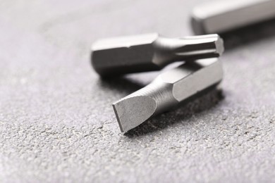 Photo of Different screwdriver bits on grey table, closeup