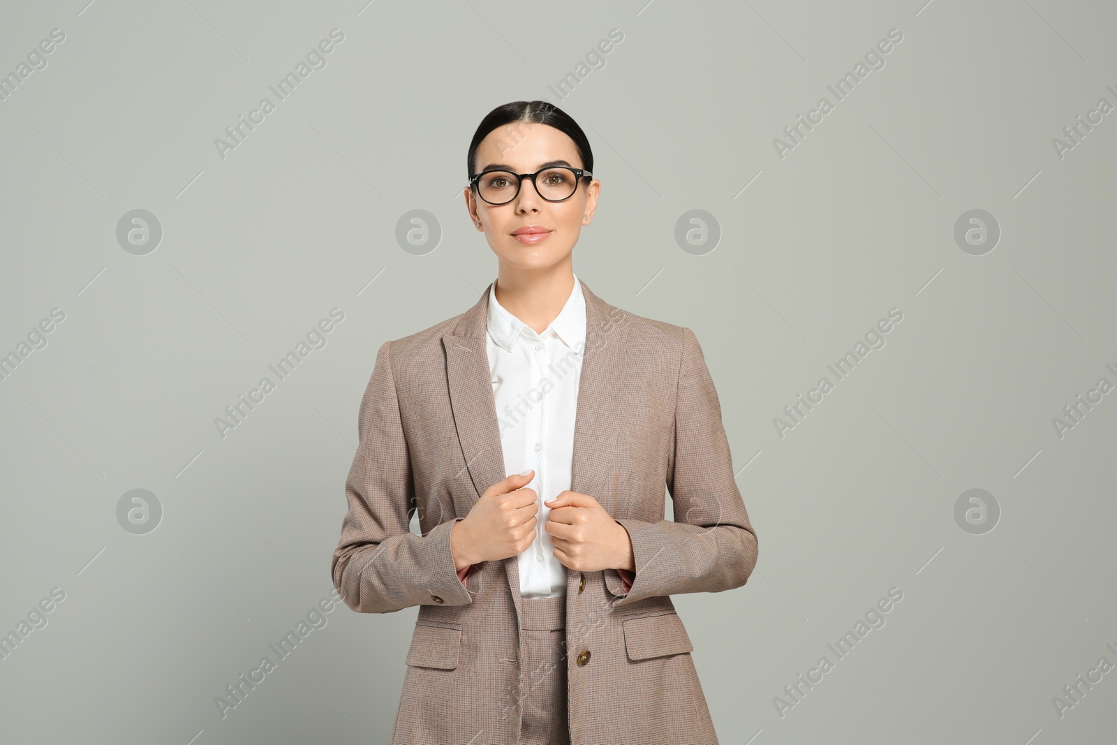 Photo of Beautiful real estate agent in nice suit on grey background