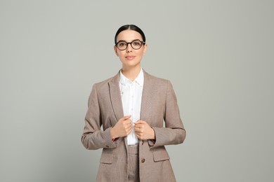 Photo of Beautiful real estate agent in nice suit on grey background