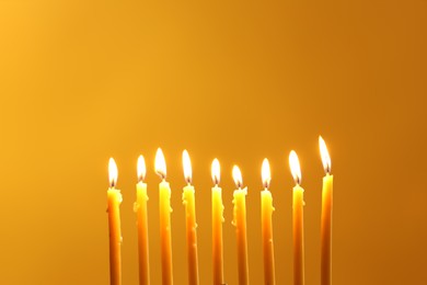 Photo of Hanukkah celebration. Burning candles on yellow background