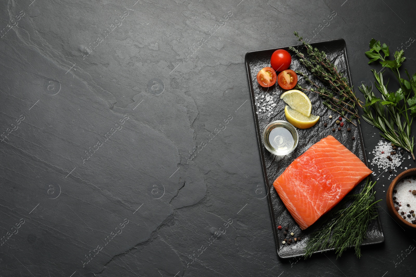 Photo of Fresh raw salmon and ingredients for marinade on black table, flat lay. Space for tex