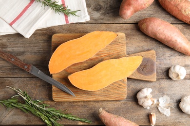 Photo of Flat lay composition with sweet potatoes and products on wooden background