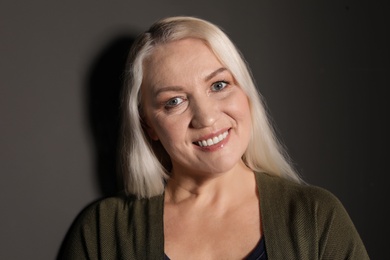 Photo of Portrait of mature woman on black background