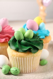 Photo of Tasty cupcakes with Easter decor on table, closeup