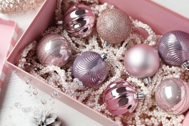 Photo of Composition with beautiful Christmas baubles on white wooden table, above view