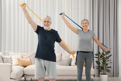 Senior couple doing exercise with fitness elastic bands at home