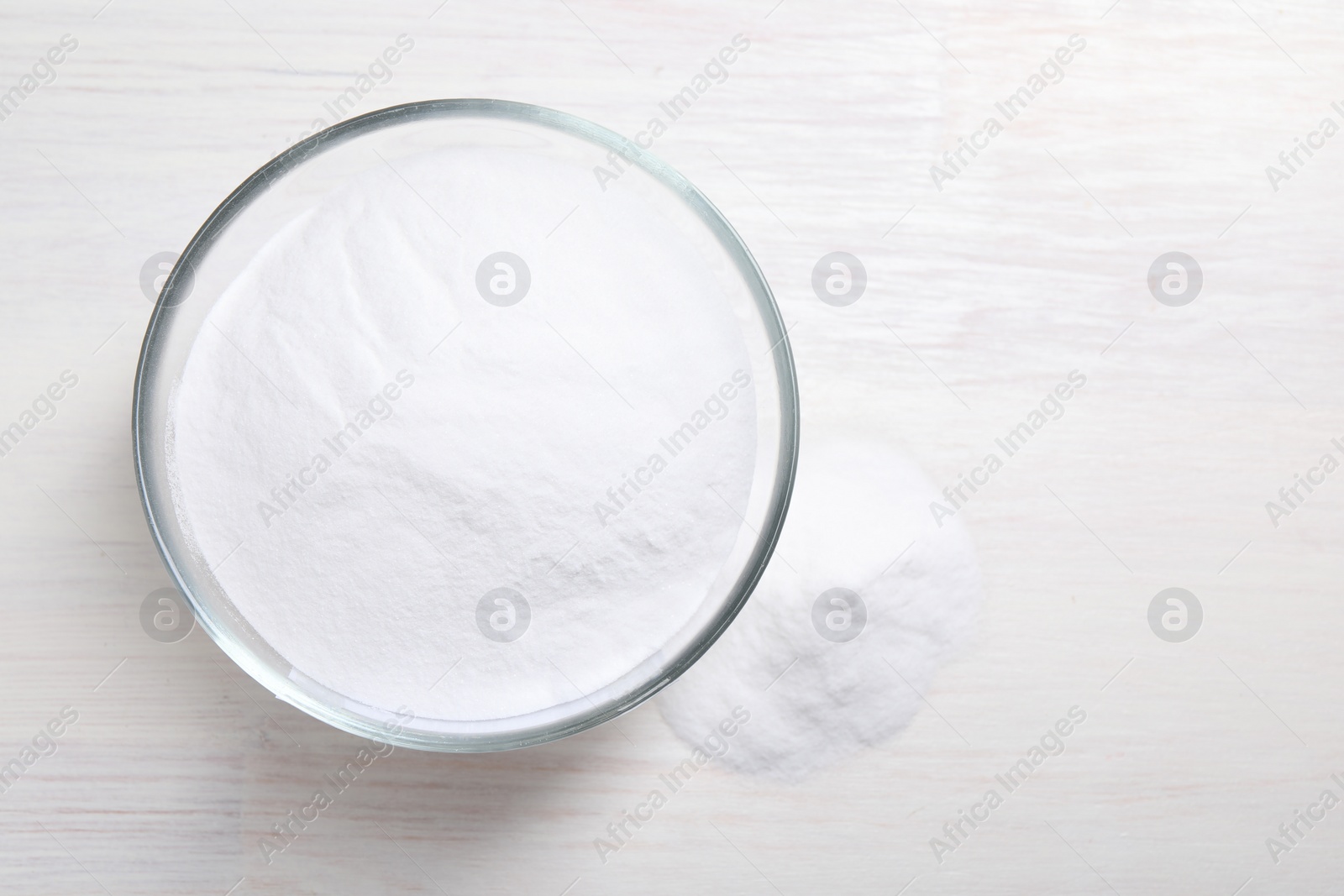 Photo of Baking soda on white wooden table, top view. Space for text