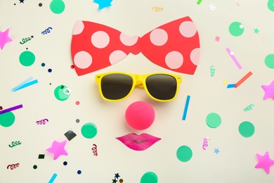 Photo of Flat lay composition with clown's face made of sunglasses and bow on white background