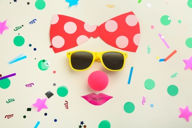 Flat lay composition with clown's face made of sunglasses and bow on white background