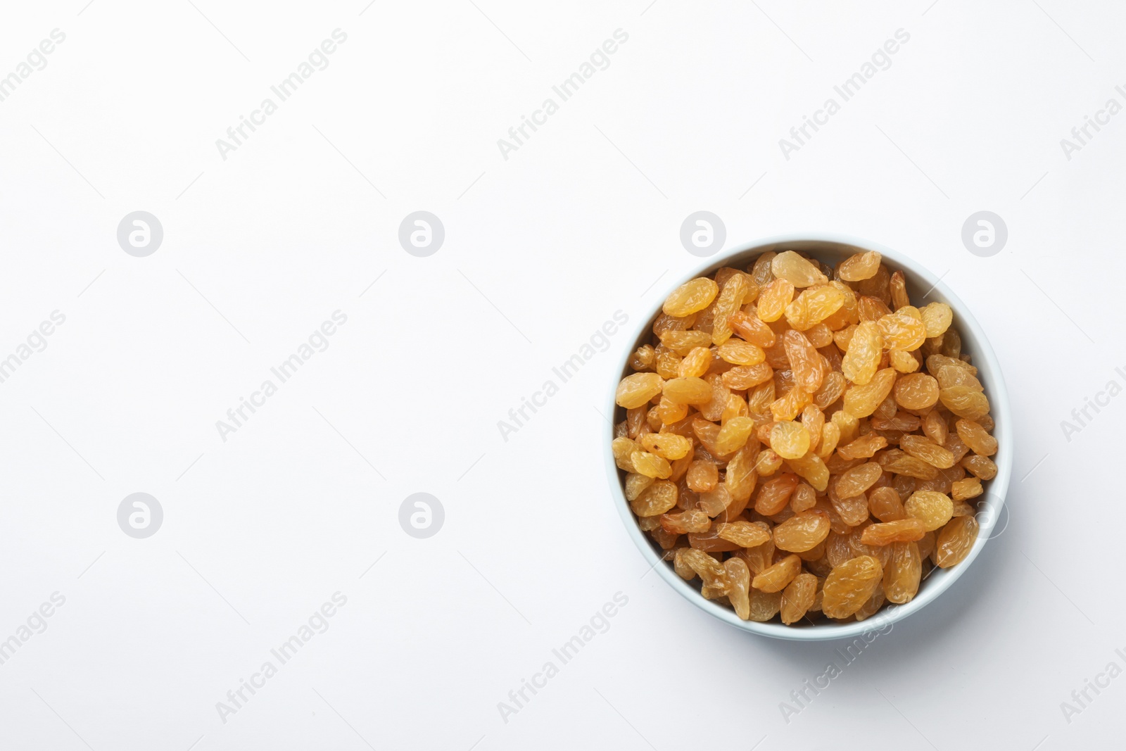 Photo of Bowl with raisins and space for text on white background, top view. Dried fruit as healthy snack