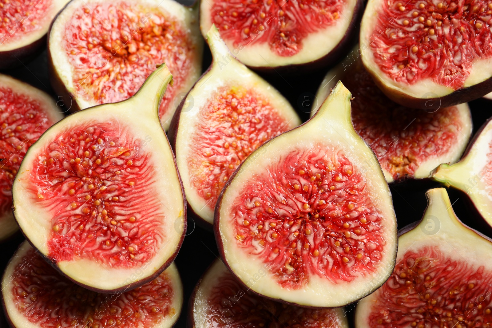 Photo of Halves of fresh ripe figs on table, top view