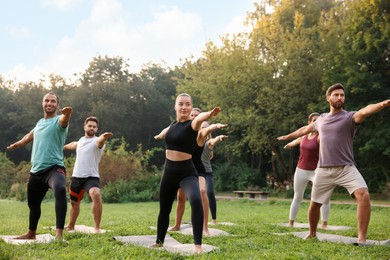 Photo of Group of people practicing yoga on mats outdoors