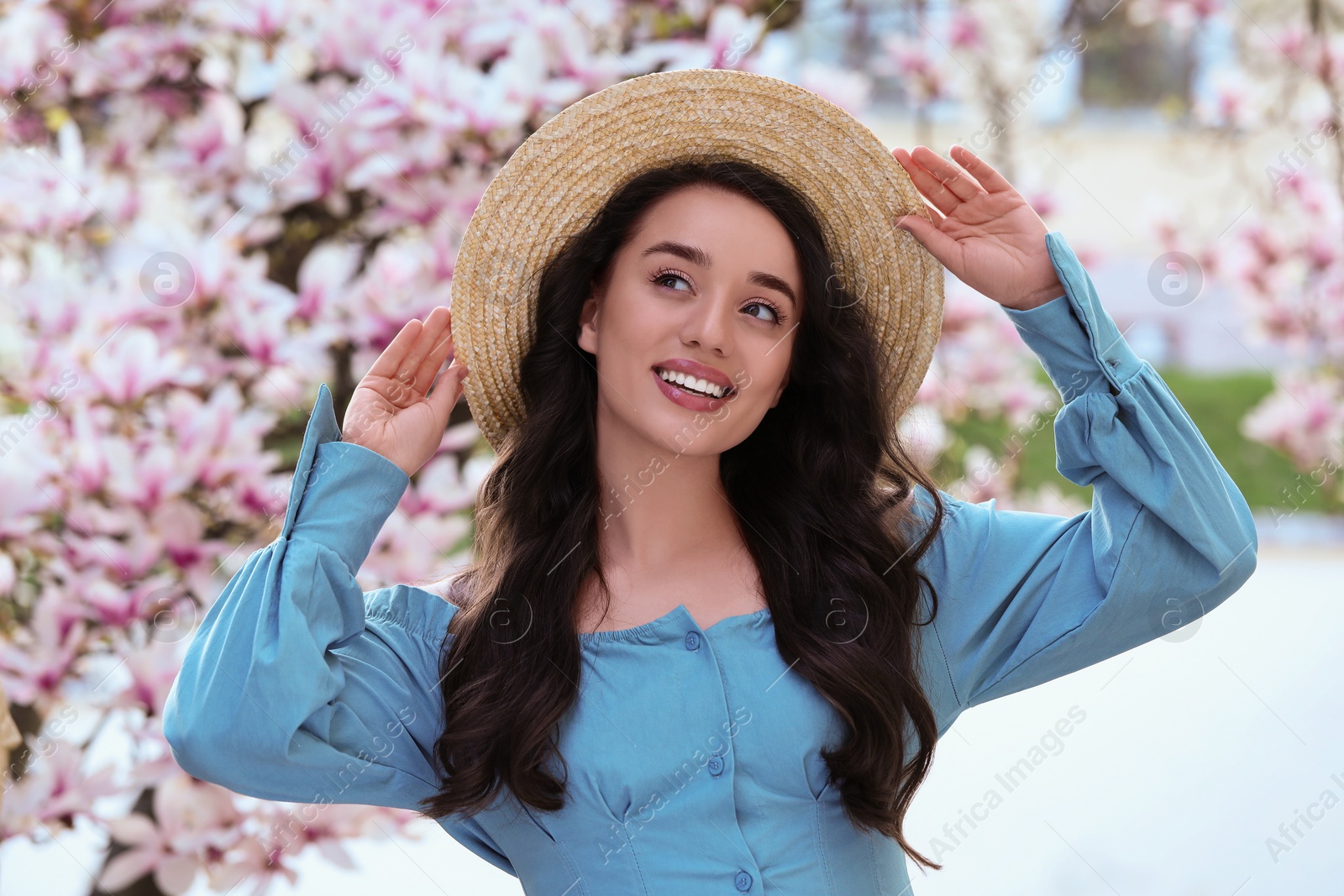 Photo of Beautiful woman near blossoming magnolia tree on spring day