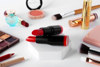 Beautiful lipsticks and cosmetic products on white table