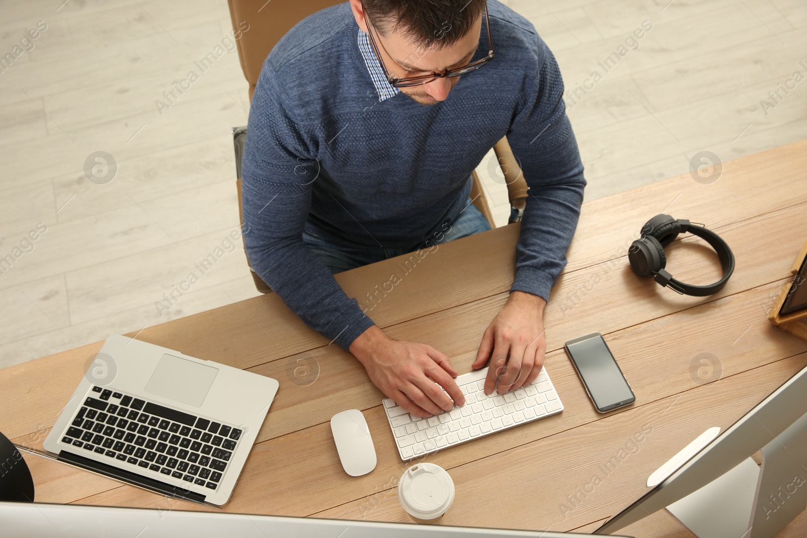 Photo of Programmer working at desk in office, top view