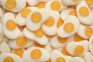 Tasty jelly candies in shape of egg as background, top view