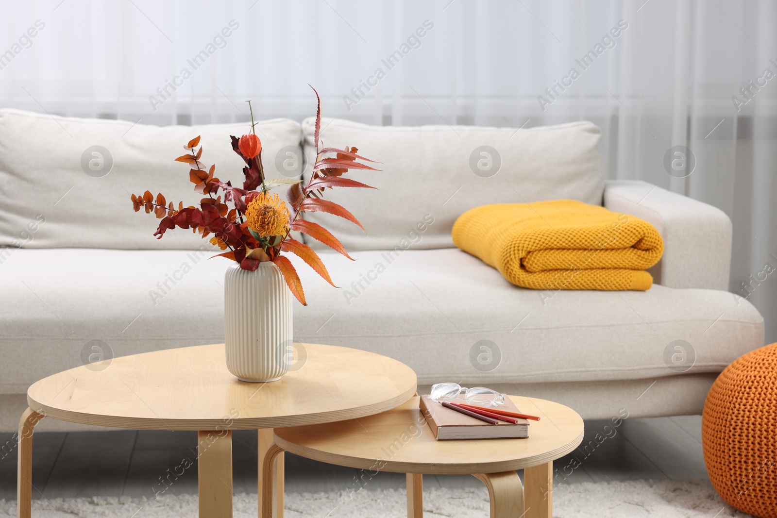 Photo of Nesting tables and comfortable sofa in living room. Interior design