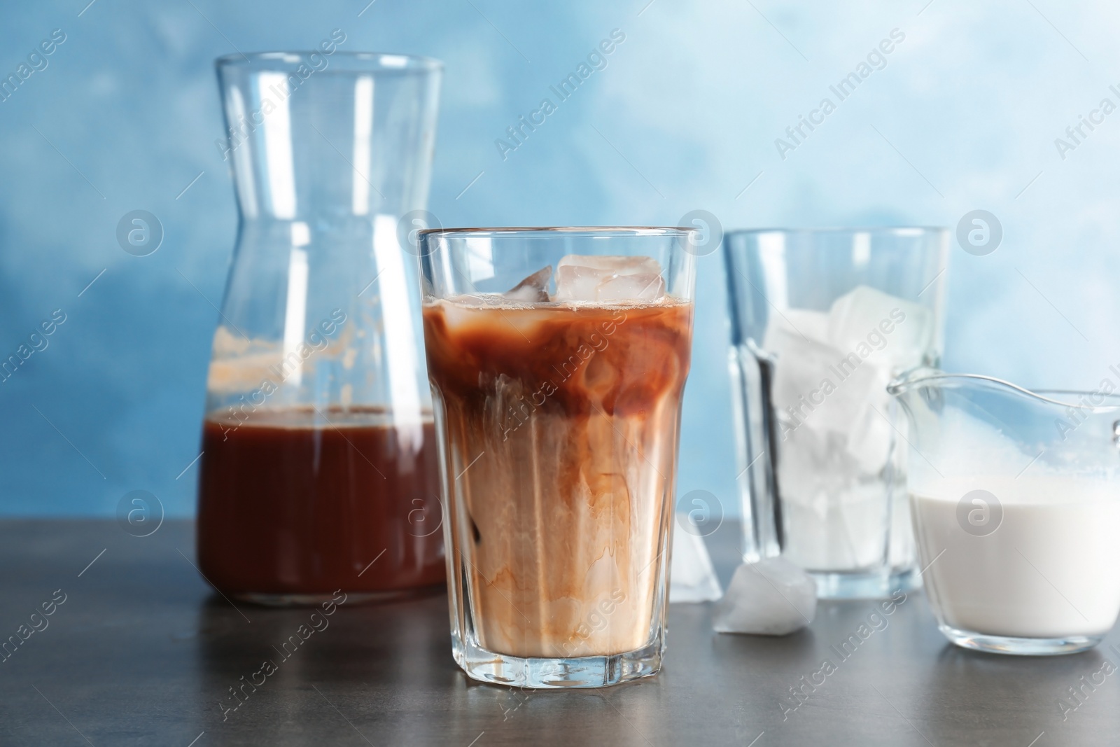 Photo of Glass with cold brew coffee and milk on table