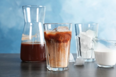 Glass with cold brew coffee and milk on table