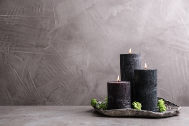 Tray with burning candles and flowers on table, space for text