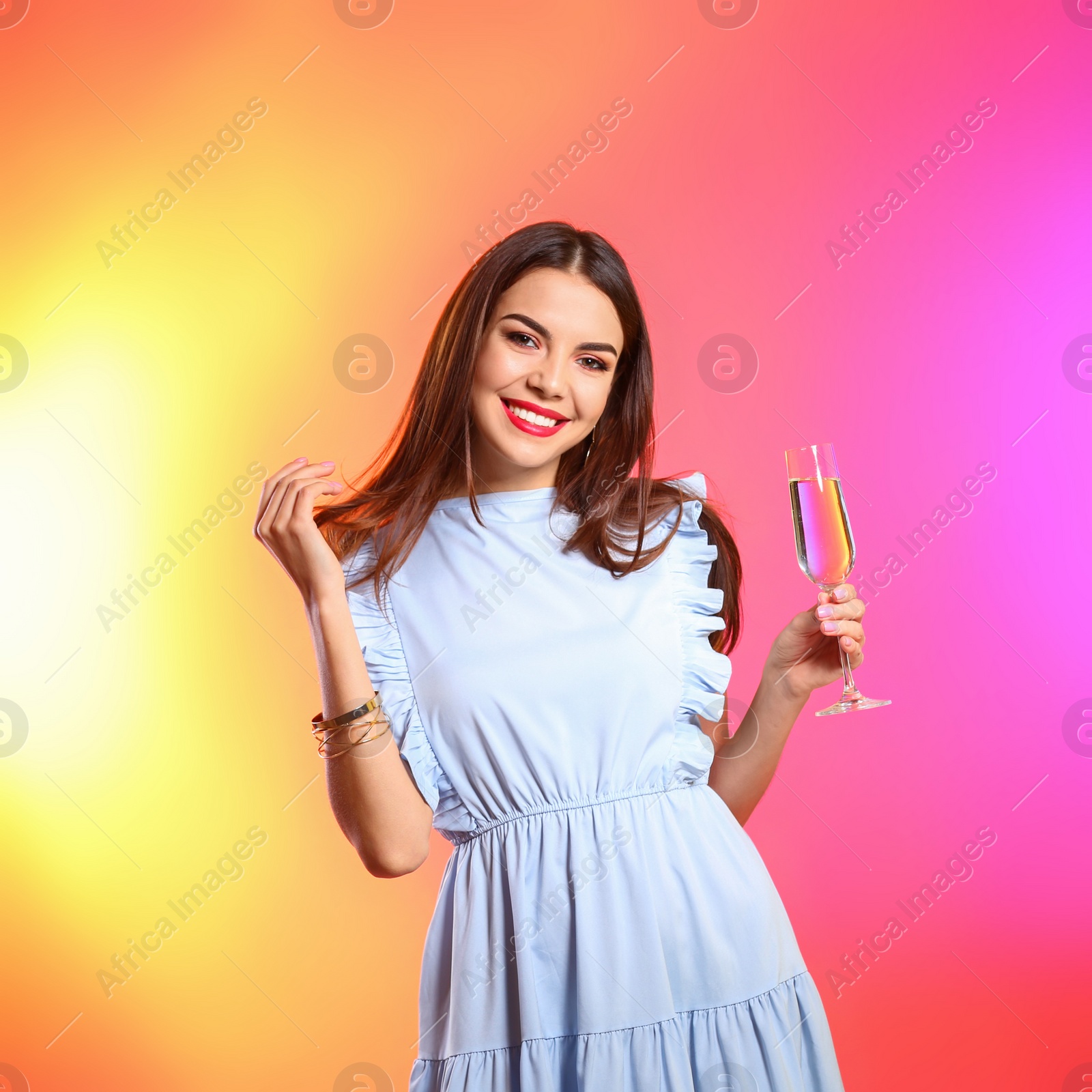 Photo of Portrait of happy woman with champagne in glass on color background