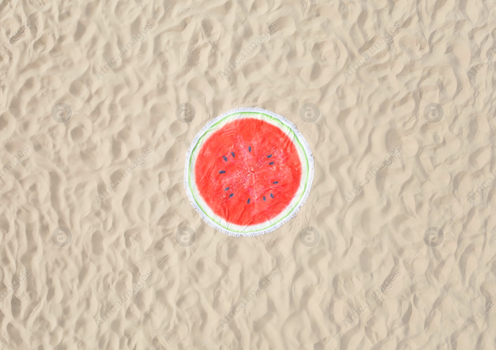 Image of Round watermelon beach towel on sand, aerial view