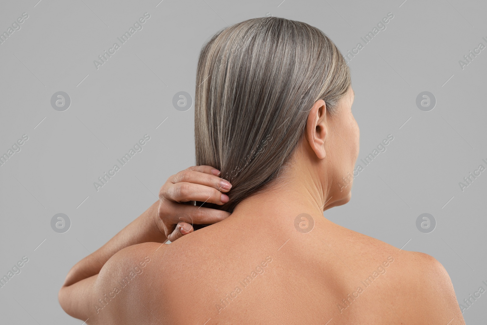 Photo of Mature woman with healthy skin on grey background