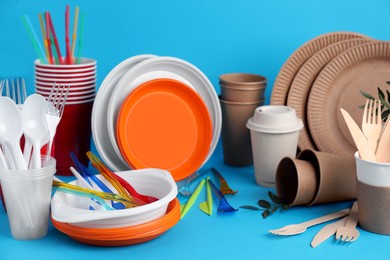 Photo of Plastic and eco disposable tableware on light blue background