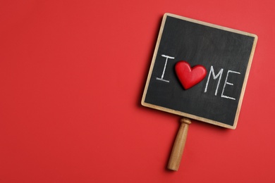 Chalkboard with phrase I Love Me and heart on red background, top view. Space for text