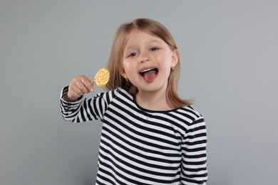 Portrait of happy girl with lollipop on light grey background