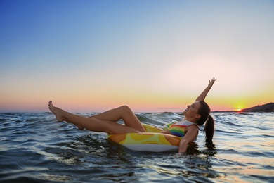 Photo of Young woman on inflatable ring in water