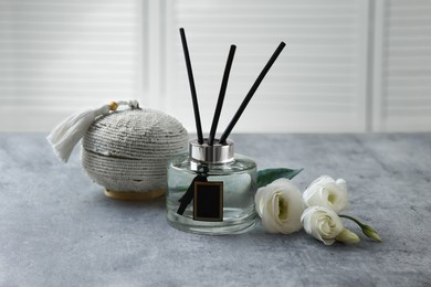 Reed diffuser, box and eustoma flowers on gray marble table