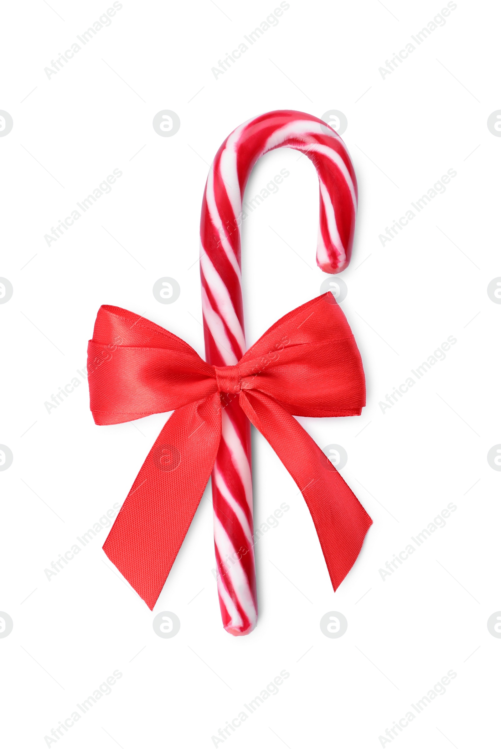 Photo of Sweet Christmas candy cane with red bow on white background, top view