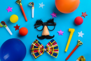 Photo of Flat lay composition with clown's accessories on light blue background